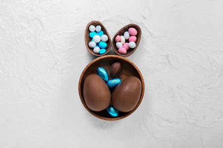 Composition with chocolate Easter eggs and candies on light backgroundの写真素材