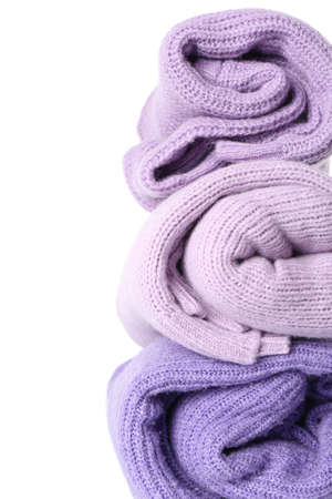 Stack of rolled lilac sweaters on white background, closeupの写真素材