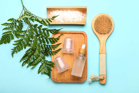 Composition with bottle of essential oil, vacuum jars for anti-cellulite massage and brush on color...