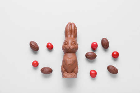 Composition with chocolate Easter bunny and candies on light backgroundの写真素材