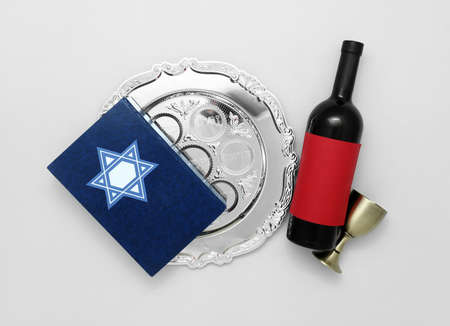 Passover Seder plate, Torah and wine on light background