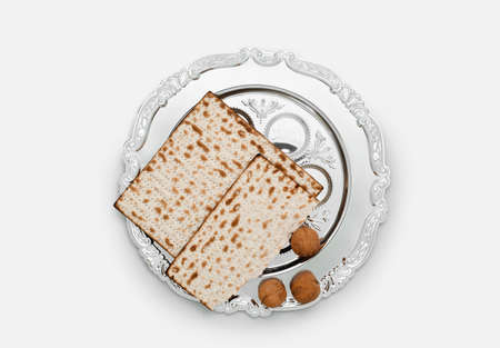 Passover Seder plate, flatbread matza and walnuts on light background