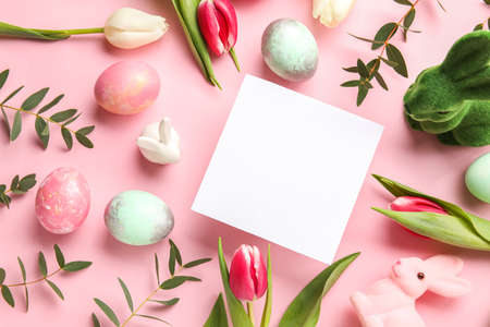 Composition with blank card, flowers and Easter eggs on pink backgroundの写真素材