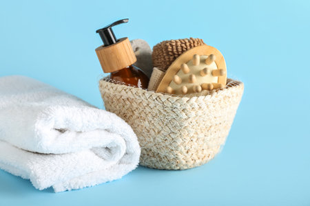 Basket with bath supplies and clean towel on color backgroundの写真素材