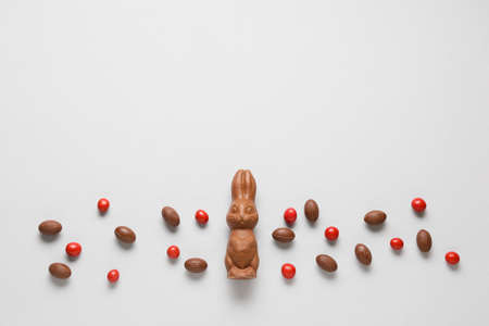 Composition with chocolate Easter bunny and candies on light backgroundの写真素材