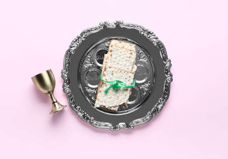 Passover Seder plate, flatbread matza and cup on pink backgroundの写真素材