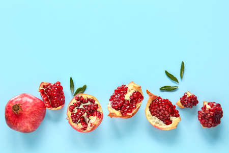 Tasty ripe pomegranate pieces on blue backgroundの写真素材