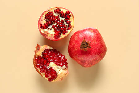 Tasty ripe pomegranates on beige backgroundの写真素材