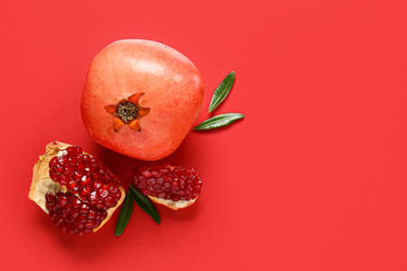 Tasty ripe pomegranate on red backgroundの写真素材