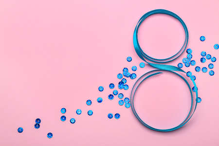 Figure 8 made of ribbon and confetti on pink background. International Women's Day celebrationの写真素材