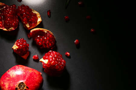 Tasty ripe pomegranate pieces on dark backgroundの写真素材