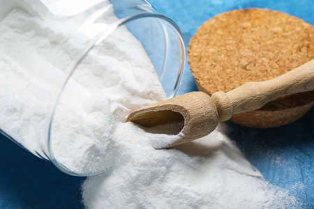 Jar with baking soda and scoop on blue background, closeupの写真素材