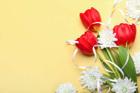 Composition with beautiful flowers for International Women's Day celebration on yellow background, closeupの写真素材