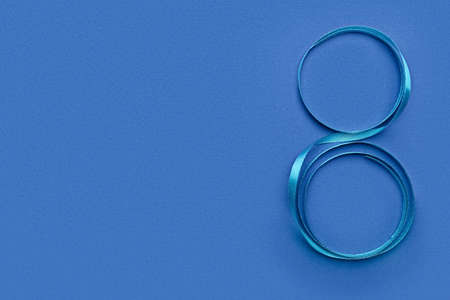 Figure 8 made of ribbon for International Women's Day celebration on blue background