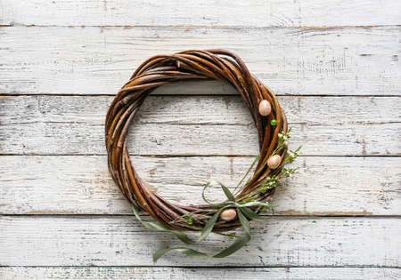 Beautiful Easter wreath with flowers on white wooden backgroundの写真素材