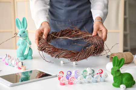 Woman making Easter wreath in light room, closeupの写真素材