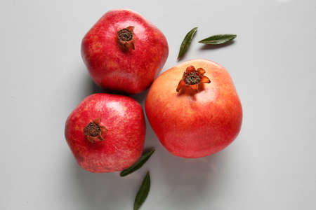 Tasty ripe pomegranates on light backgroundの写真素材