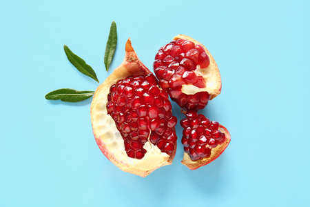 Tasty ripe pomegranate pieces on blue backgroundの写真素材