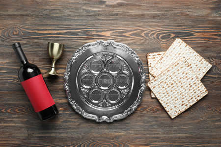 Passover Seder plate, flatbread matza and wine on wooden backgroundの写真素材