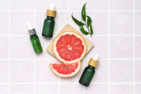 Bottles of grapefruit oil on color backgroundの写真素材