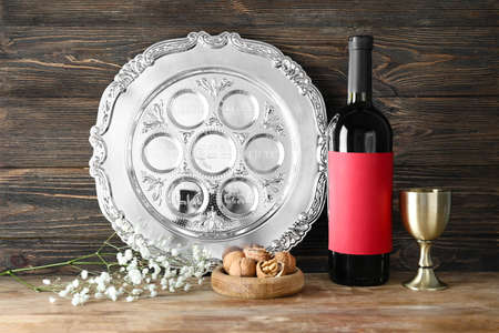 Passover Seder plate with walnuts and wine on wooden backgroundの写真素材