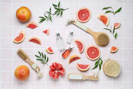 Bottles of grapefruit oil with bathing supplies on color backgroundの写真素材