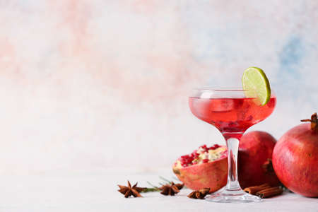 Glass of tasty pomegranate cocktail on light backgroundの写真素材