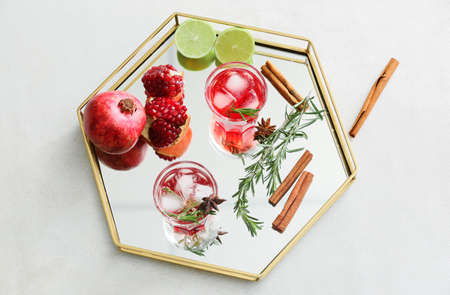 Glasses of tasty pomegranate cocktail and fruits on white backgroundの写真素材