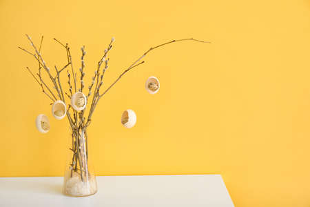 Creative composition with pussy willow branches and Easter eggs on table near color wallの写真素材