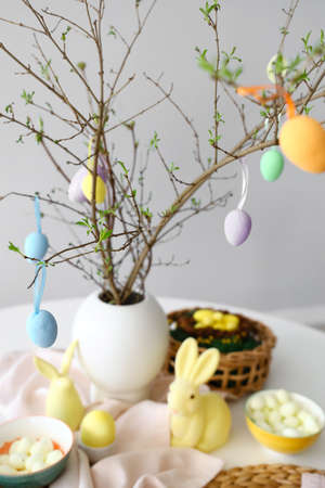 Tree branches decorated with Easter eggs on served table