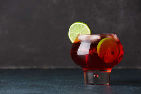 Glass of tasty pomegranate cocktail on black backgroundの写真素材