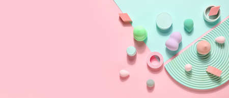 Colorful makeup sponges and decor on pink background with space for text, top viewの写真素材