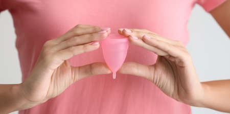 Woman holding menstrual cup, closeupの写真素材