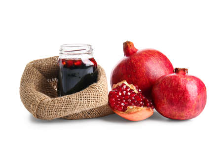 Jar of pomegranate molasses and fresh fruits on white backgroundの写真素材