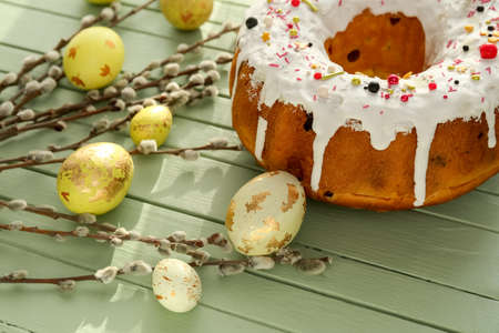Tasty Easter cake with eggs and pussy willow branches on color wooden background, closeup