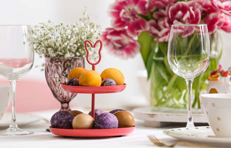Stand with Easter eggs on festive table