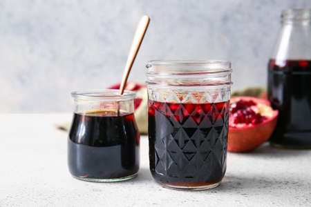 Jars of pomegranate molasses on light backgroundの写真素材
