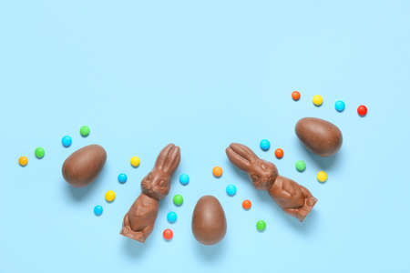 Chocolate Easter bunnies and eggs on blue background
