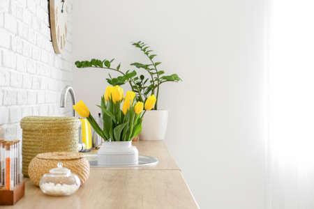 Bouquet of beautiful yellow tulips in kitchen sinkの写真素材