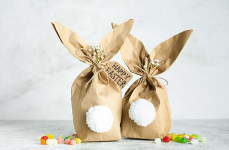 easter bunny gift bags and candies on light background