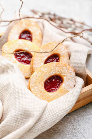 Box with delicious Easter cookies on light background