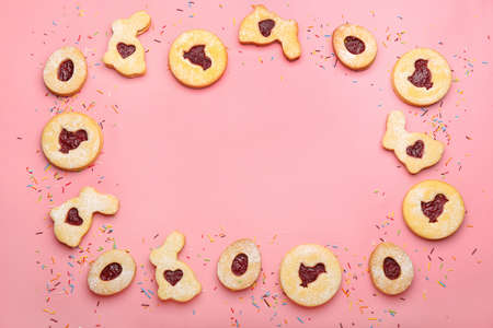 Frame made of delicious Easter cookies on pink background