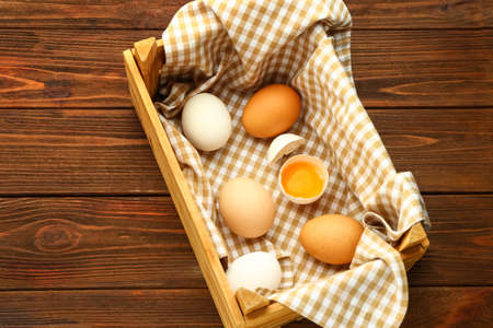 Box with fresh chicken eggs on wooden background