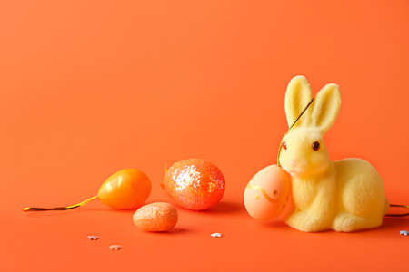 Cute Easter bunny and eggs on orange backgroundの写真素材