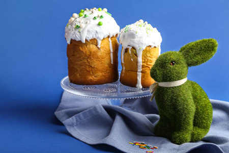 Cute Easter bunny and cakes on blue backgroundの写真素材