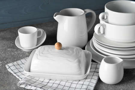 Set of stylish dinnerware on gray wooden background