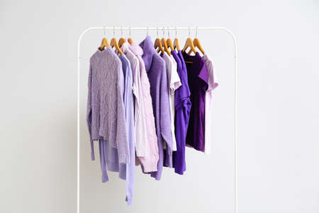 Rack with clothes in purple shades on light backgroundの写真素材