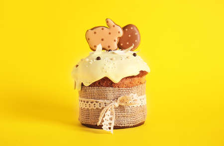 Delicious Easter cake decorated with cookies on yellow backgroundの写真素材