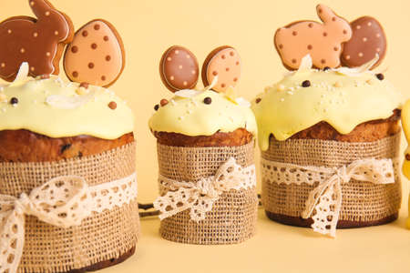 Delicious Easter cakes decorated with cookies on beige background