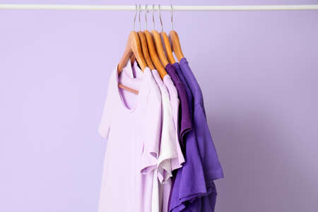 Rack with t-shirts in purple shades on lilac backgroundの写真素材